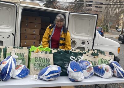 woman standing behind table with turkeys and grocery bags