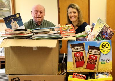 Charlie Utermohle with a woman receiving donated books