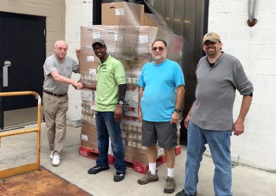 Charlie Utermohle and three male volunteers receiving a food delivery