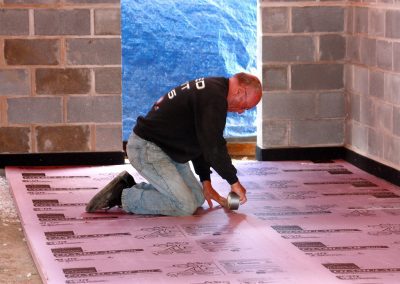 Charlie Utermohle on hands and knees at work in a building